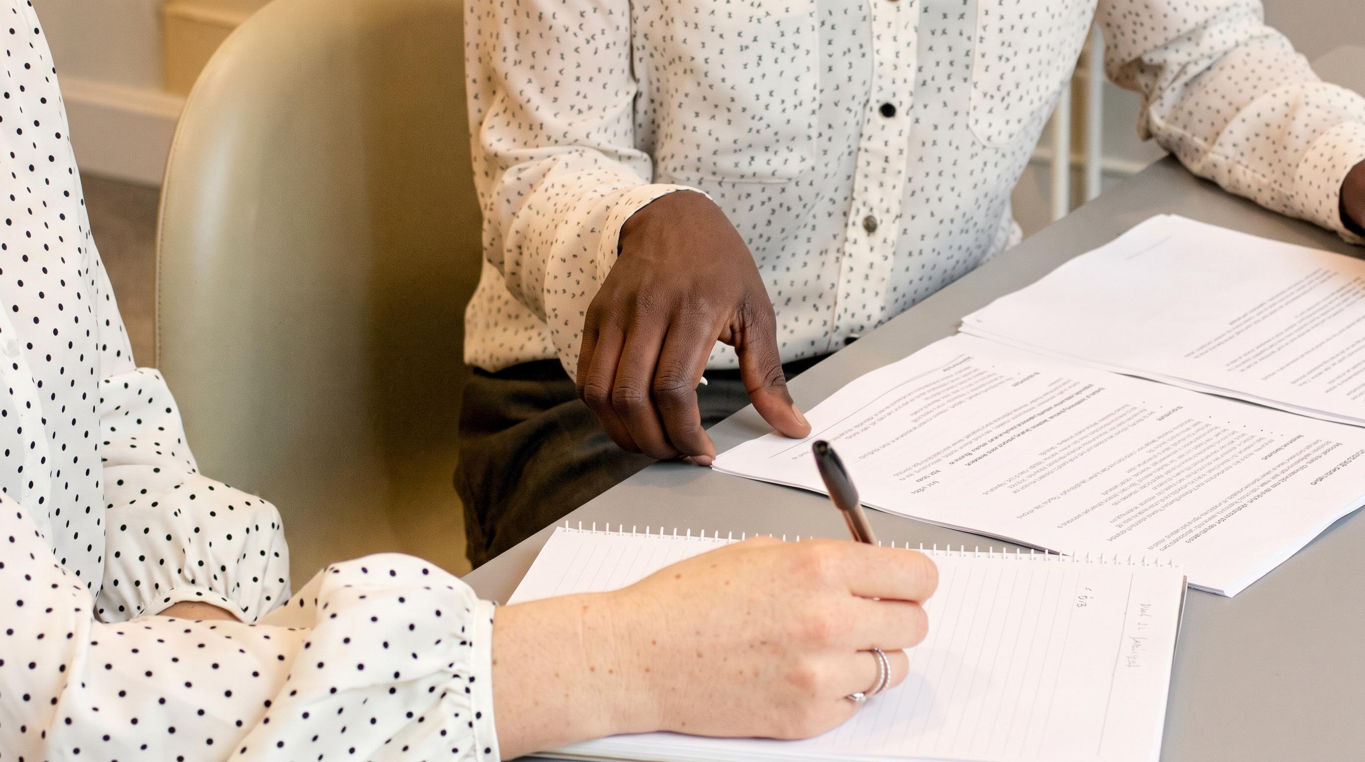 Two people working through documents at a table